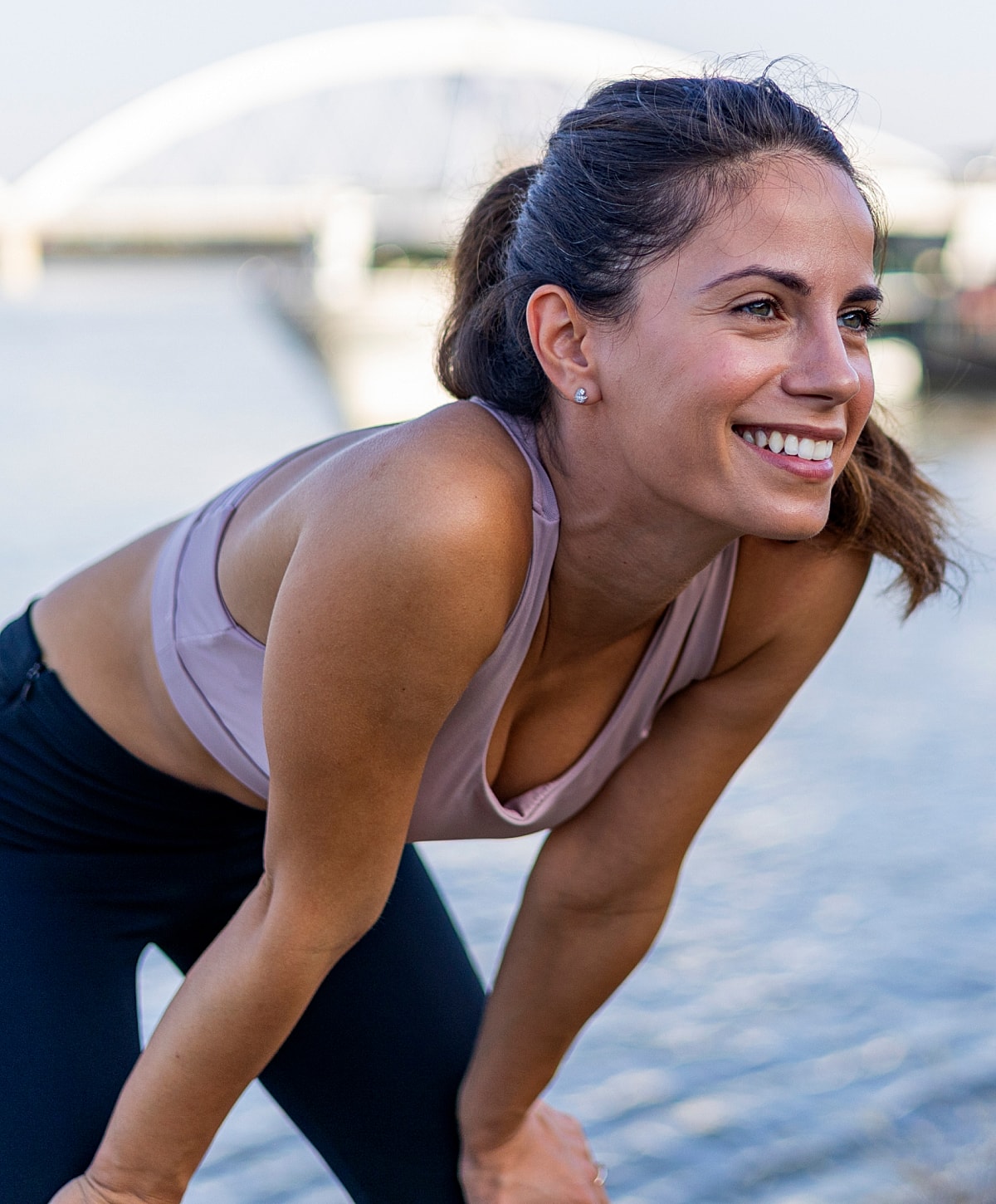 Smiling woman exercising by the water.