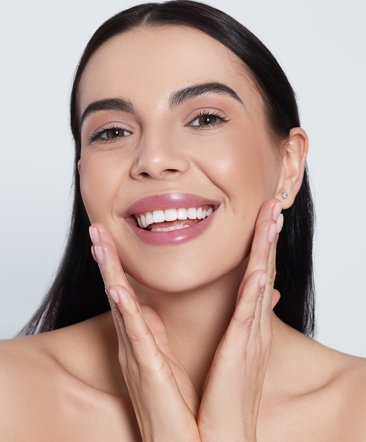 Smiling woman showcasing healthy, glowing skin.